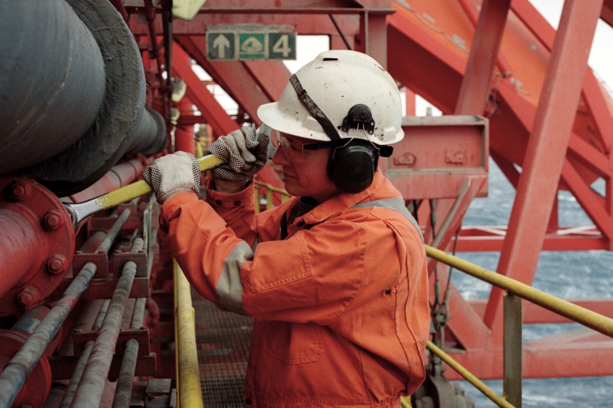 Man wearing safety gear working on oil rig.