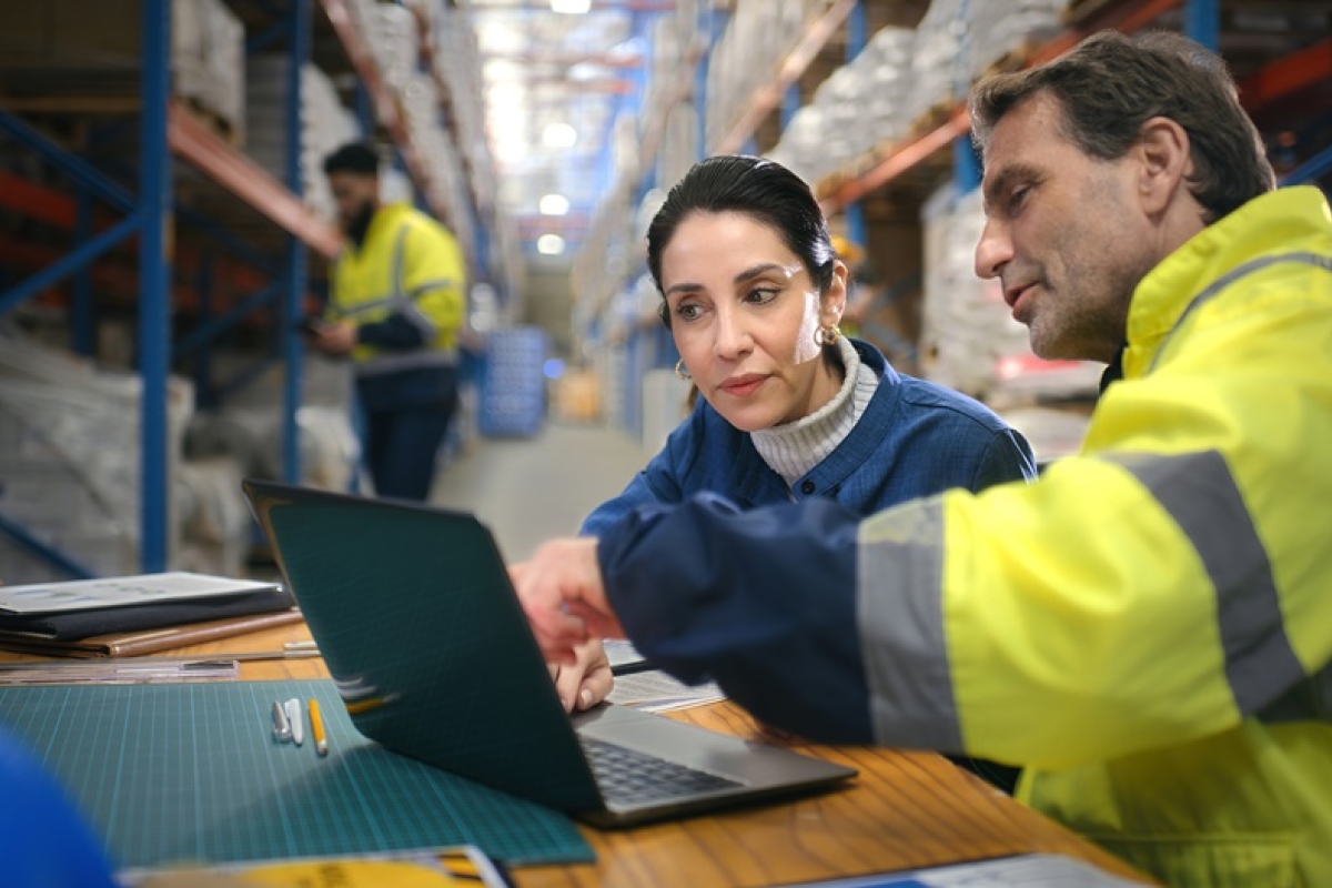 Female supervisor coordinating a scheduled shipment of products with male employee 