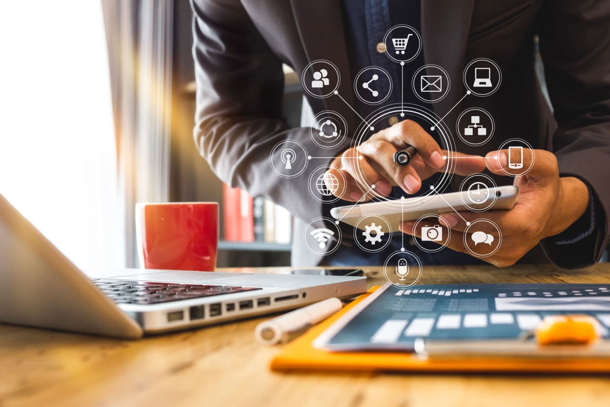 close up of person working with smart phone and laptop and digital tablet computer in modern office with virtual icon diagram