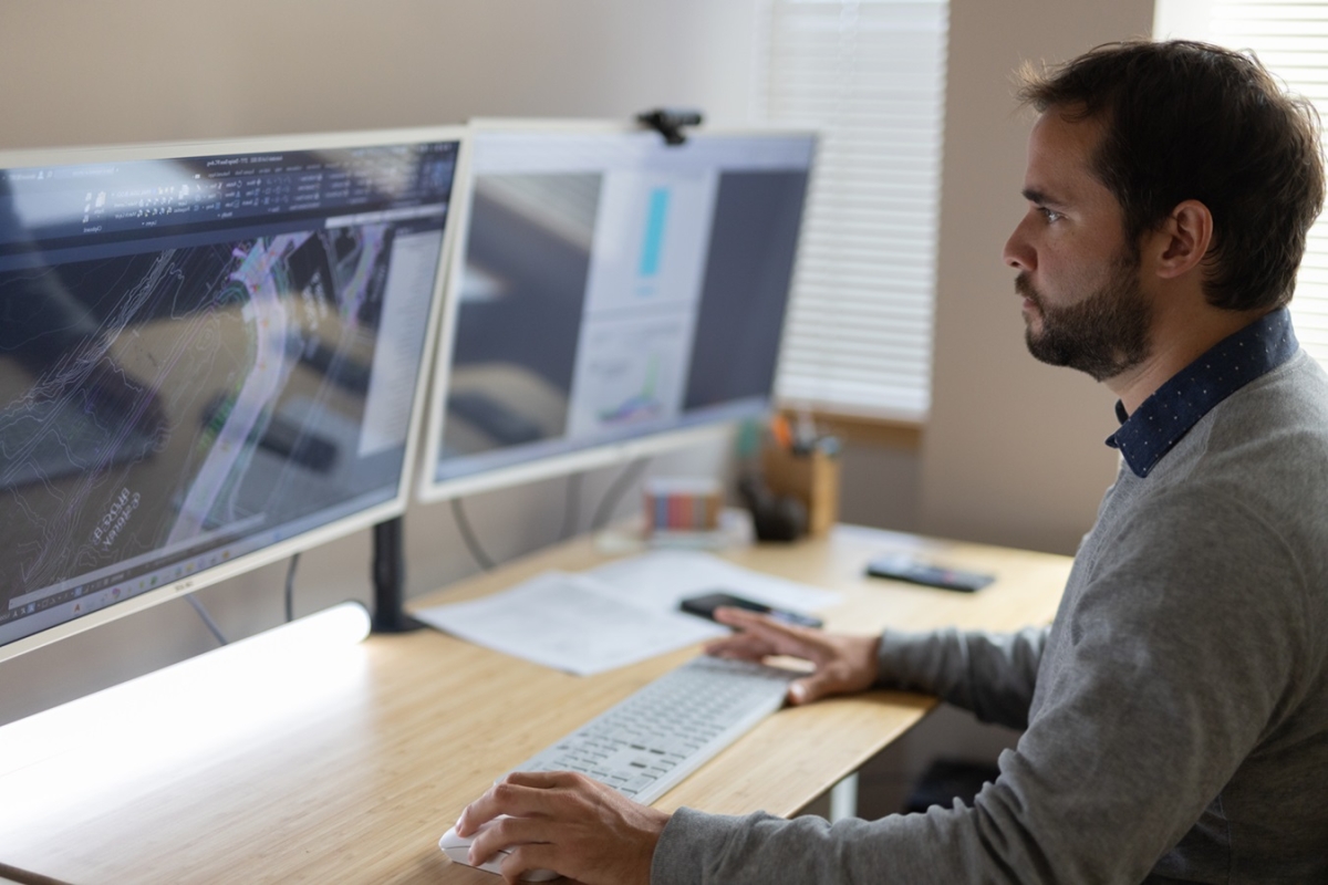 Male civil engineer drafting on his multiple computer screens