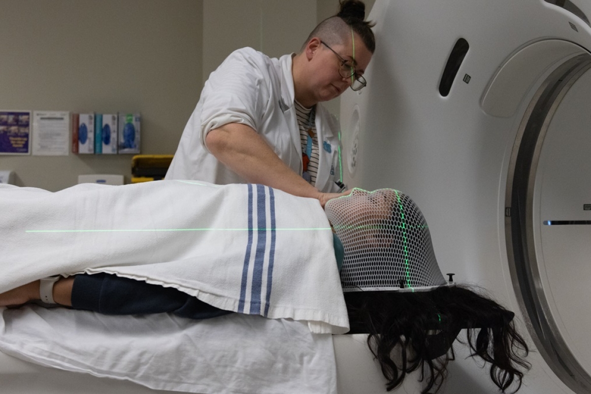 Female radiation therapist preparing a patient for treatment