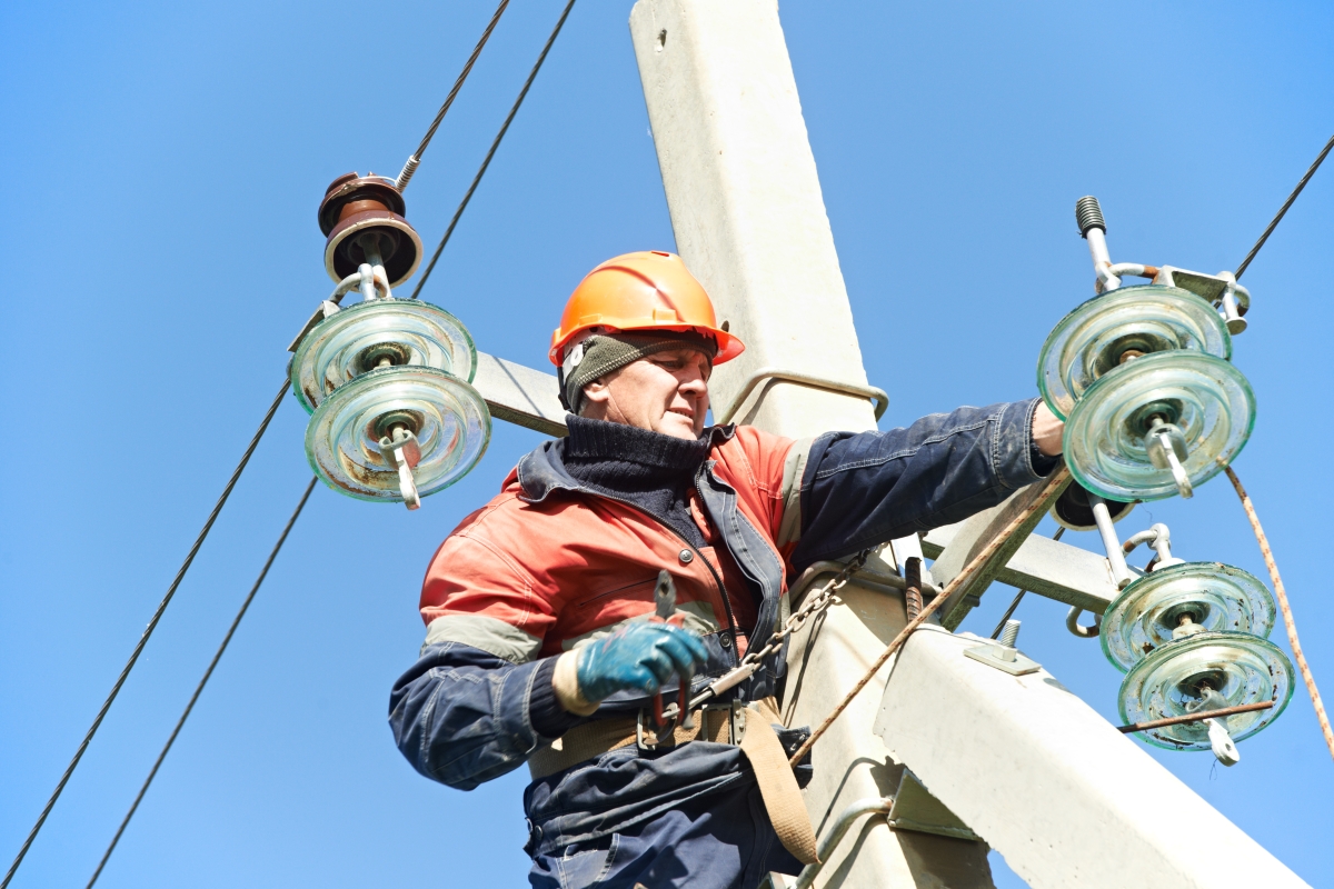 male worker harnessed up a telephone poll doing maintenance