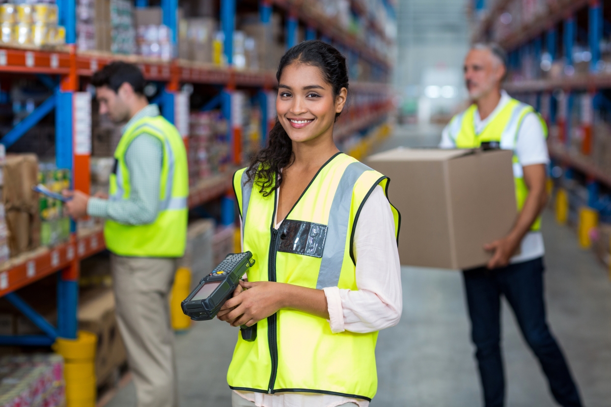 bipoc female holding a scanning device and working in a warehouse