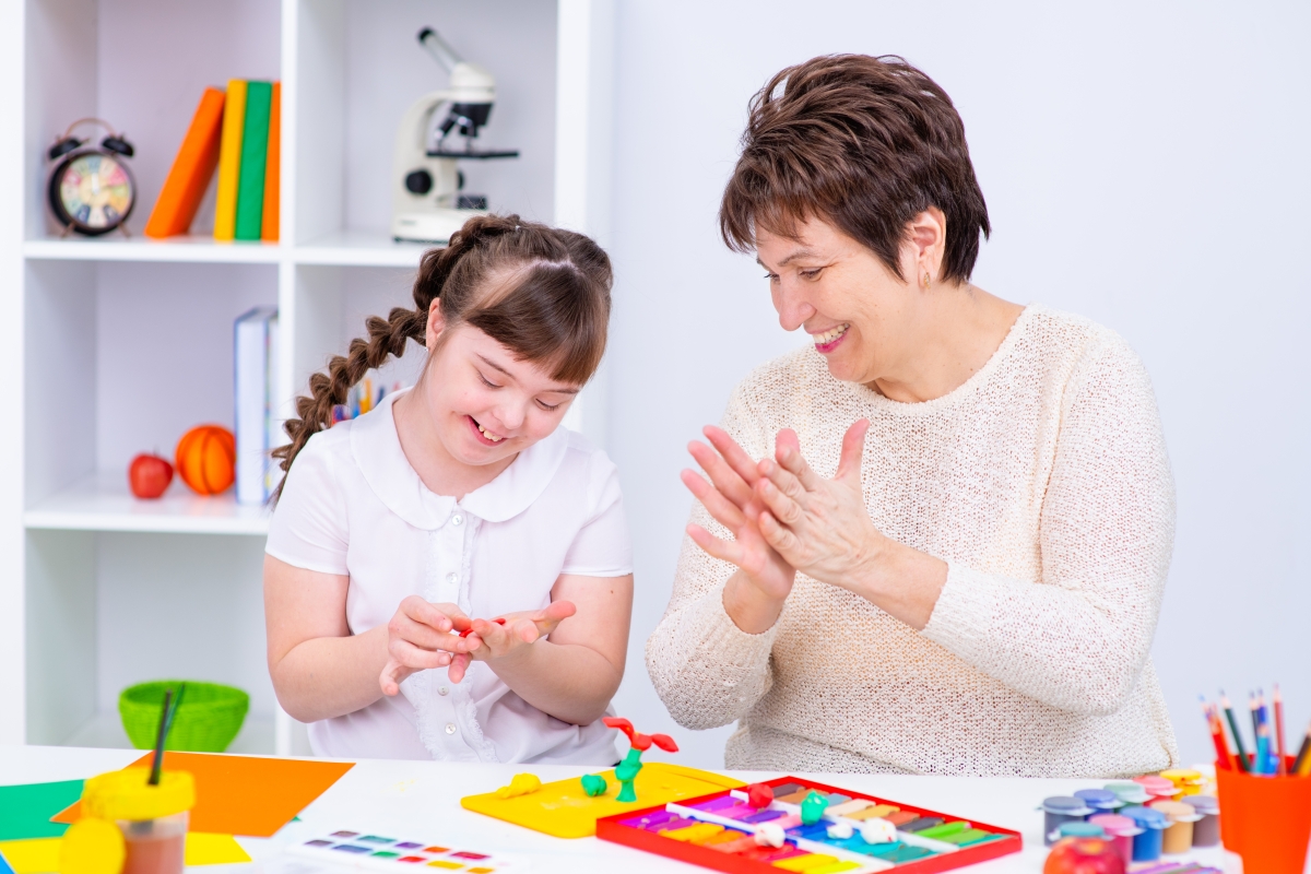woman encouraging a disabled child as she plays