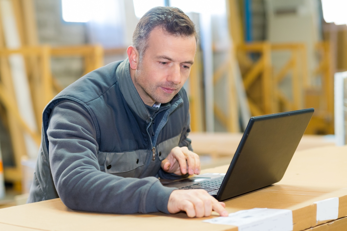 man on laptop at a desk in an industrial setting