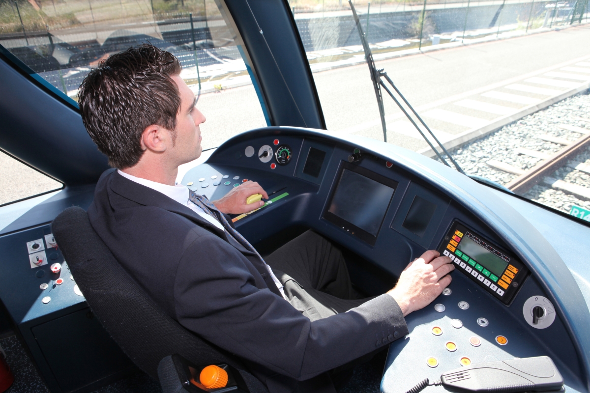 man driving a locomotive on tracks