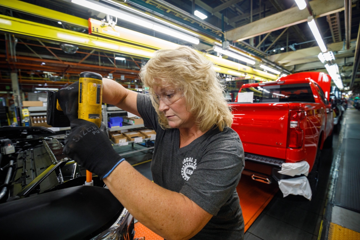 person working on a vehicle on an assembly line