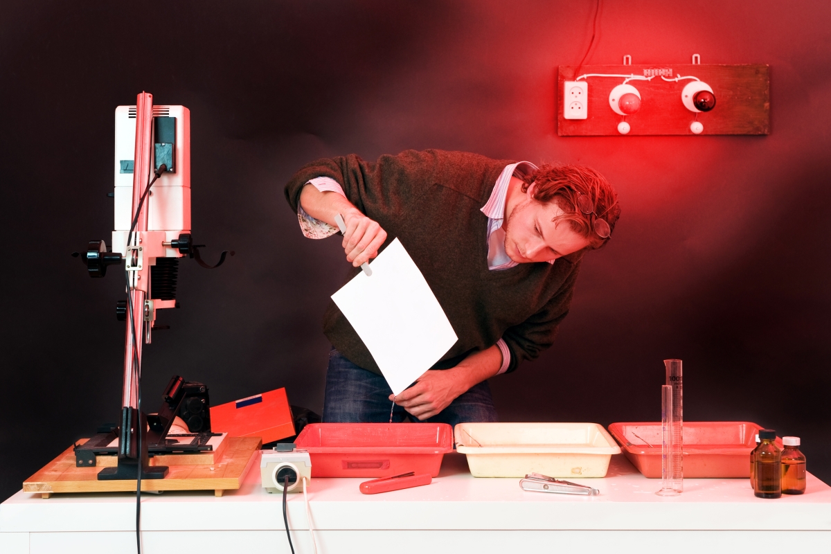 person checking a photo in a darkroom