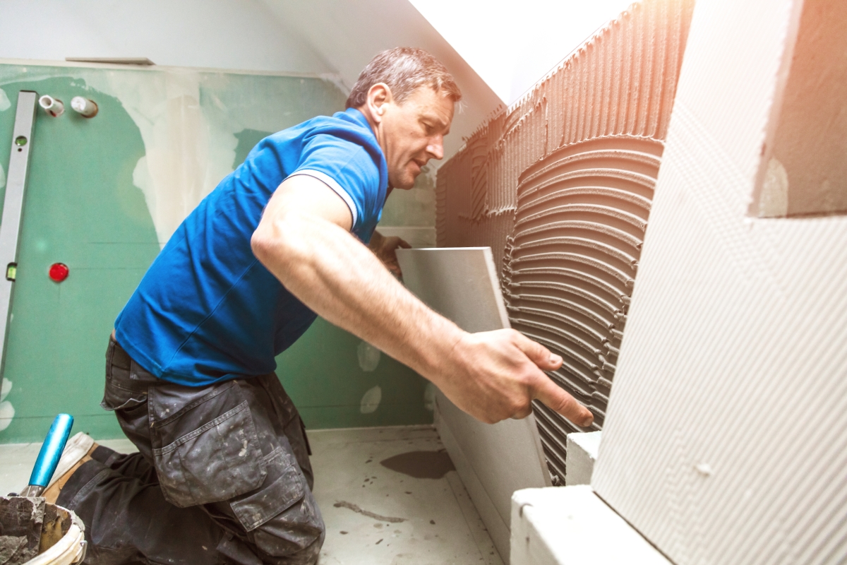 male worker kneeling and laying tile