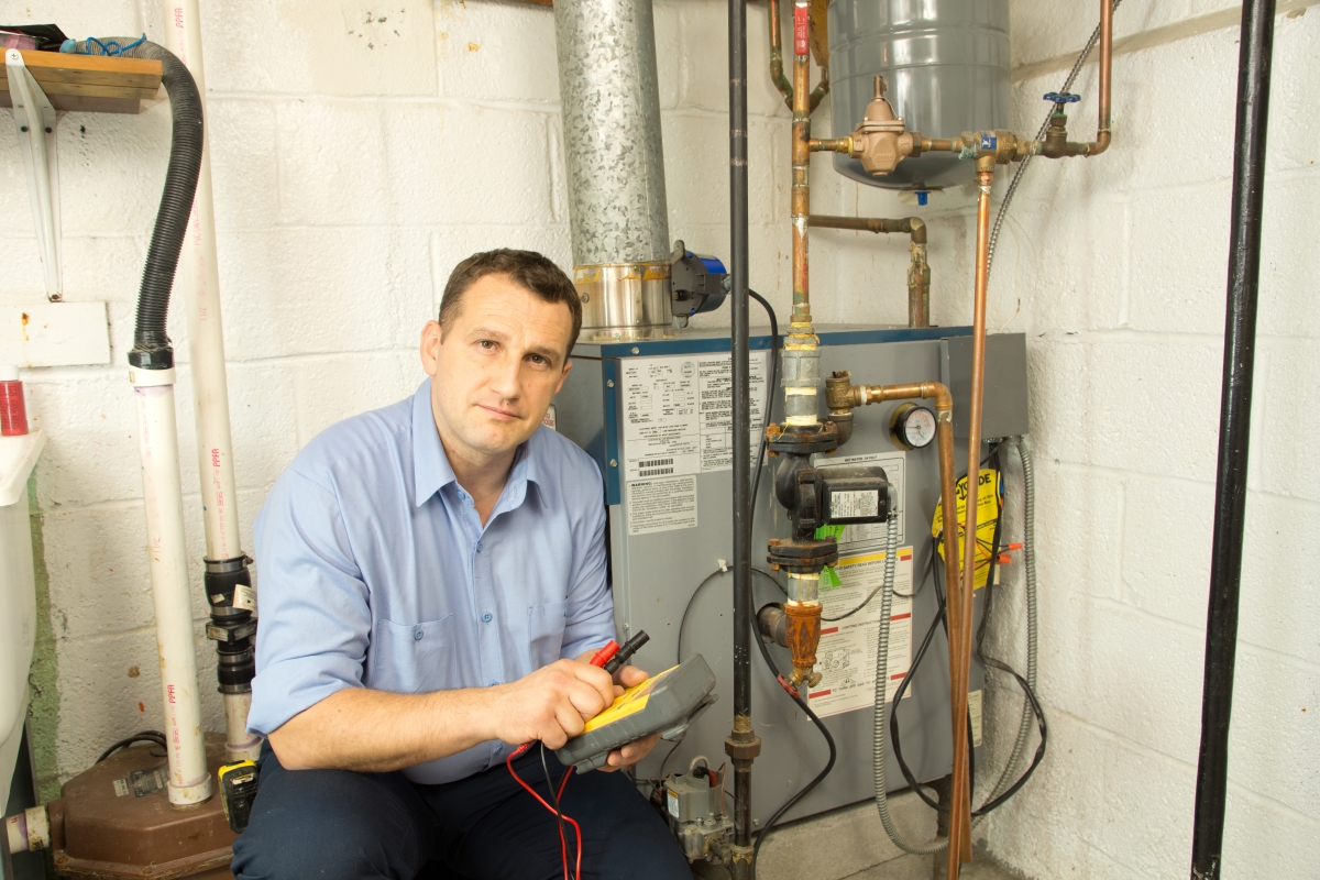 man working on heating equipment in a building