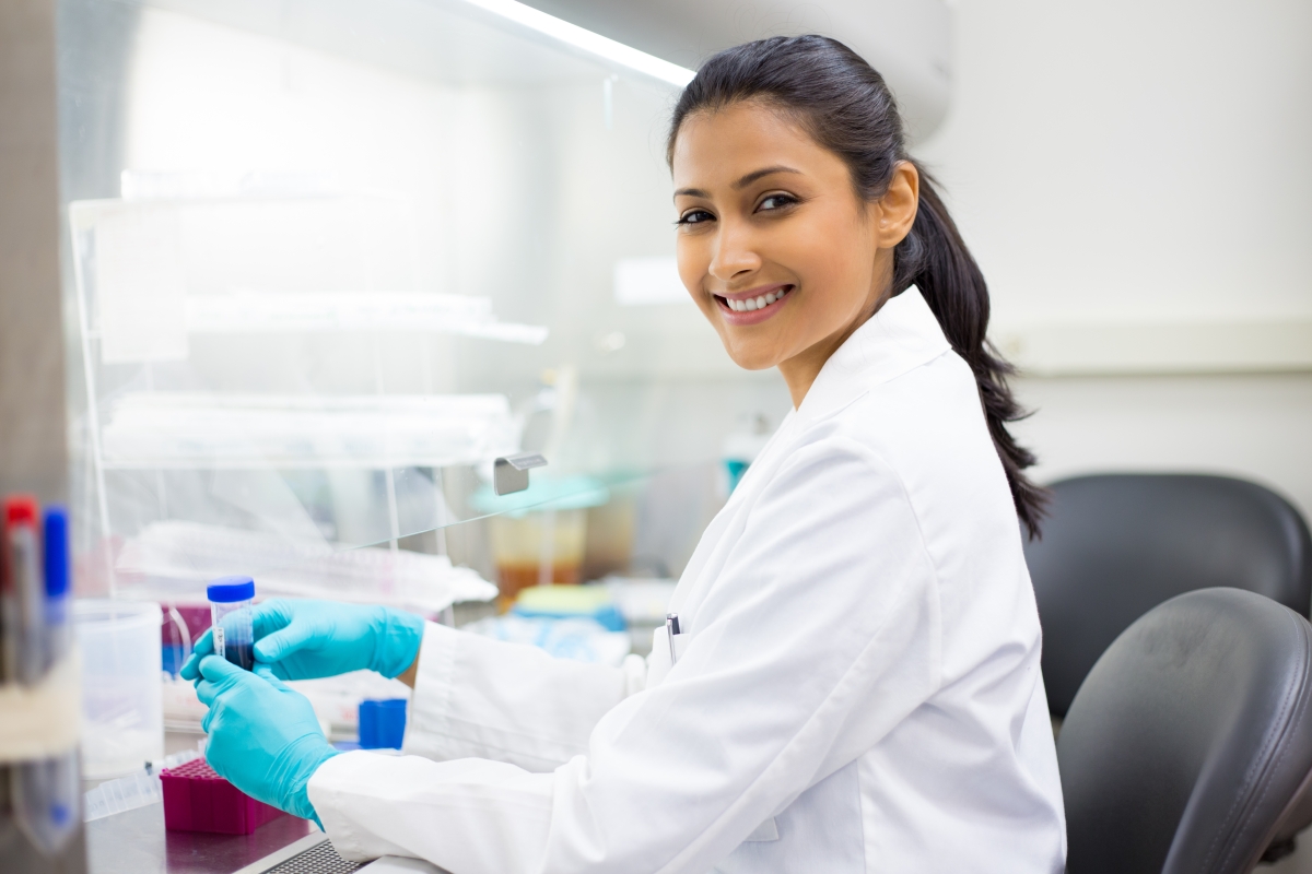 female in lab coat working with test tubes