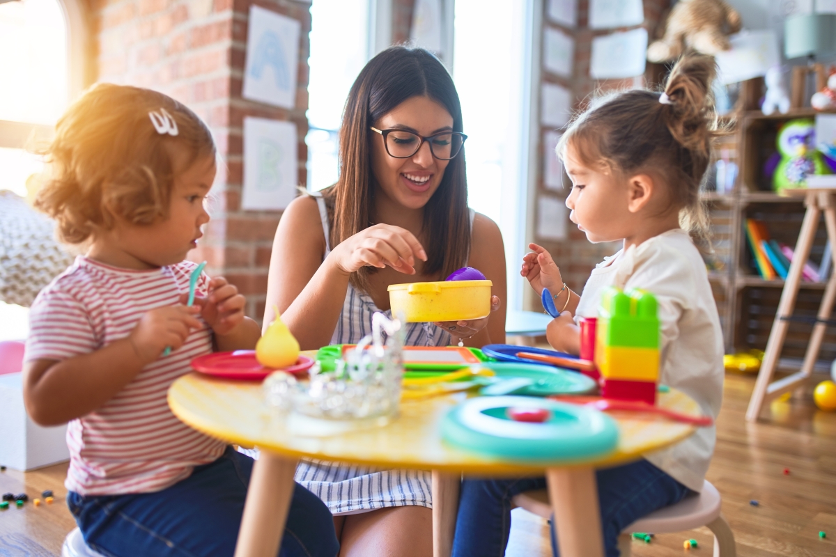 young woman playing with two children