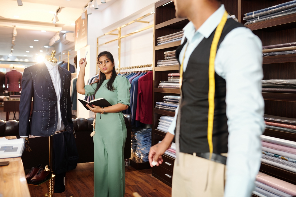 client being fitted for a suit in a men's fashion store