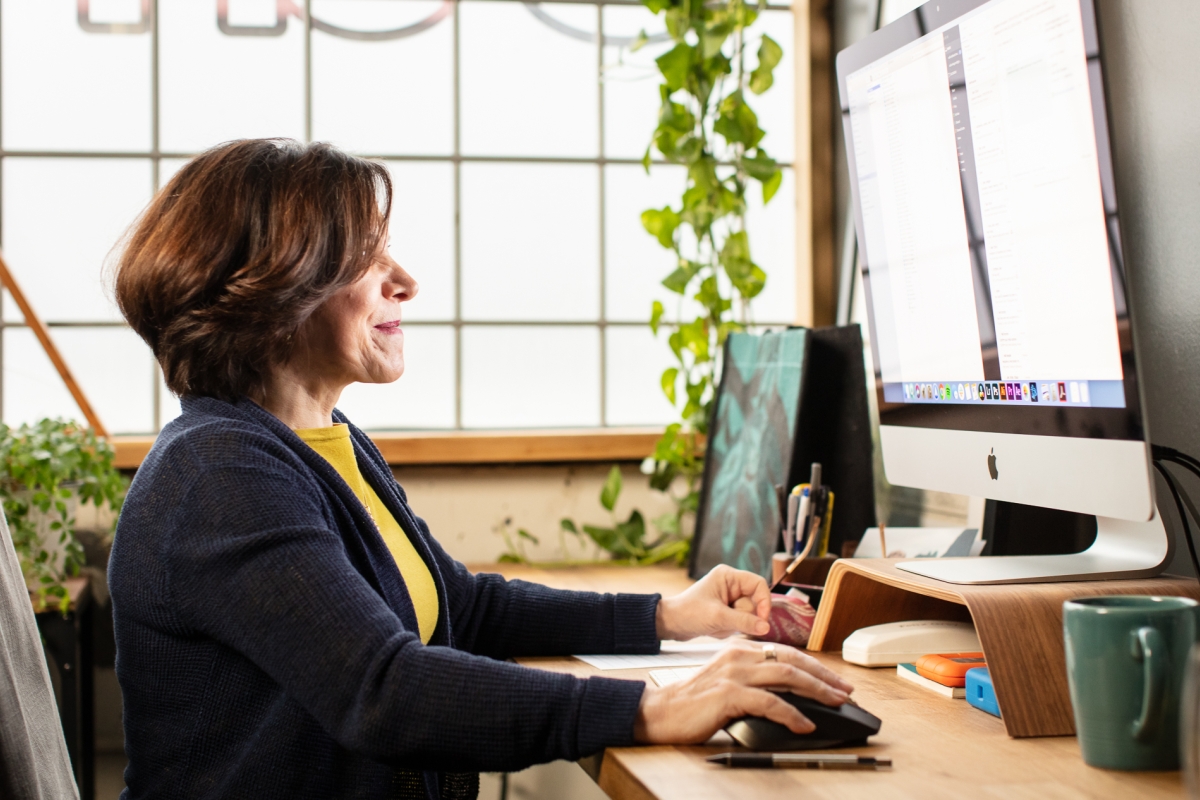 female working on computer near a window