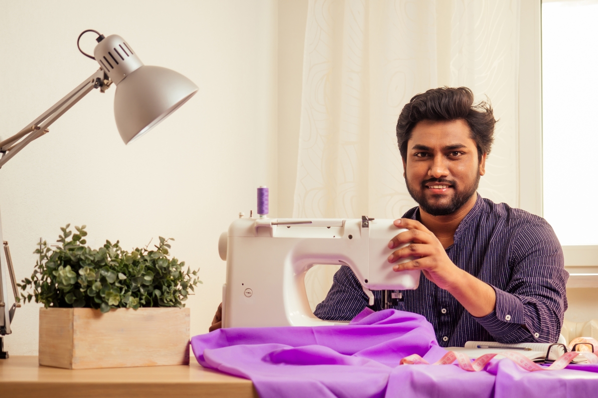 man using a sewing machine to work on a garment