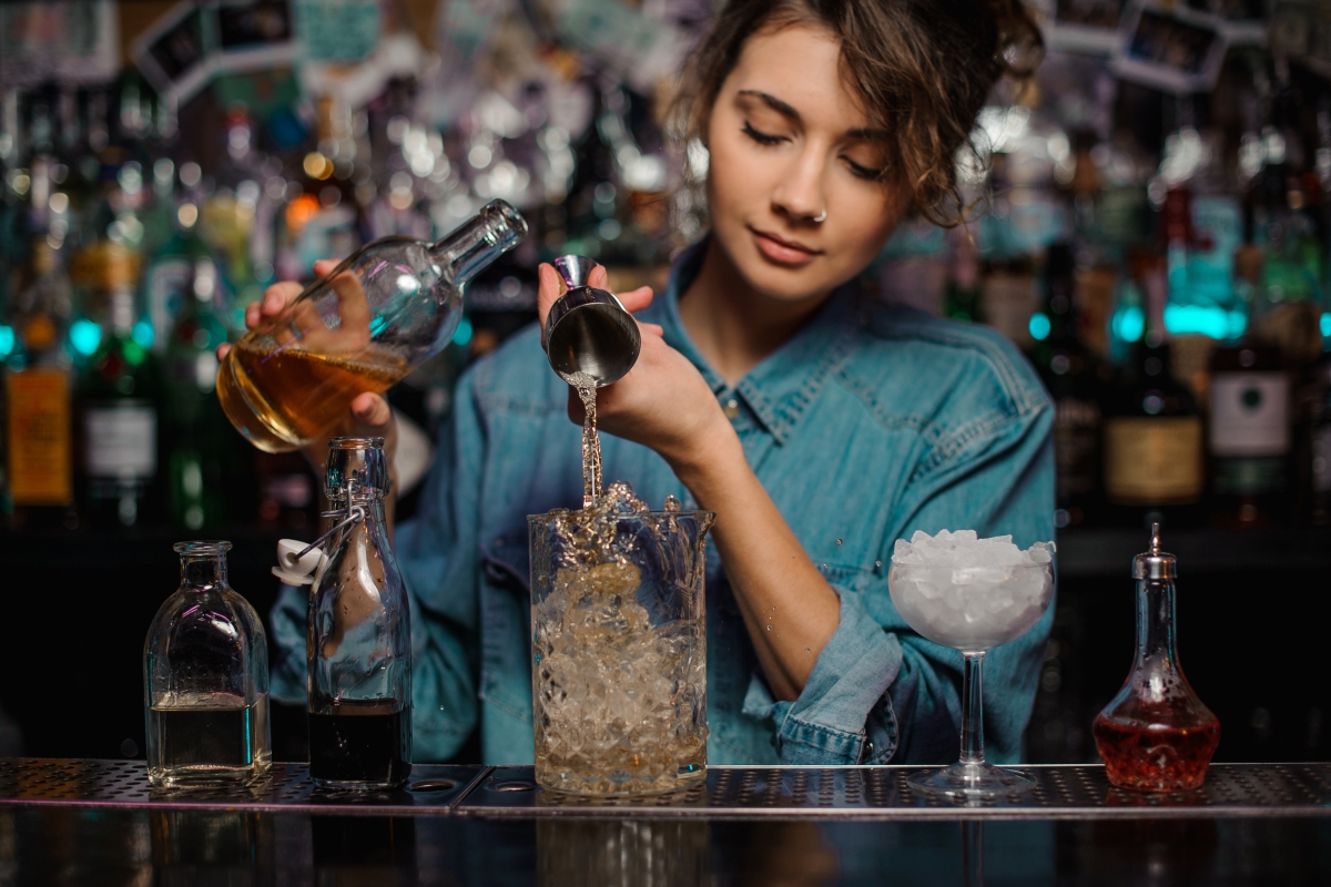 female bartender mixing a drink behind the bar