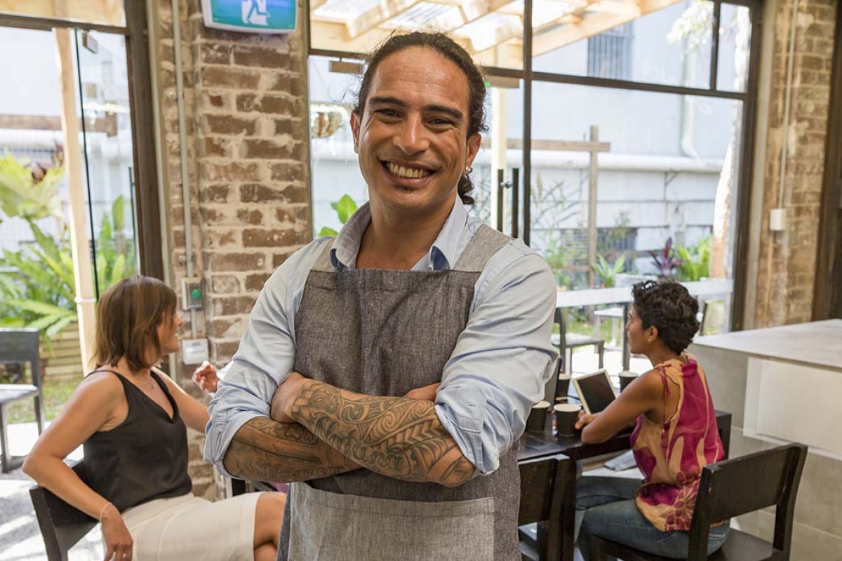 smiling male store owner with arms crossed 