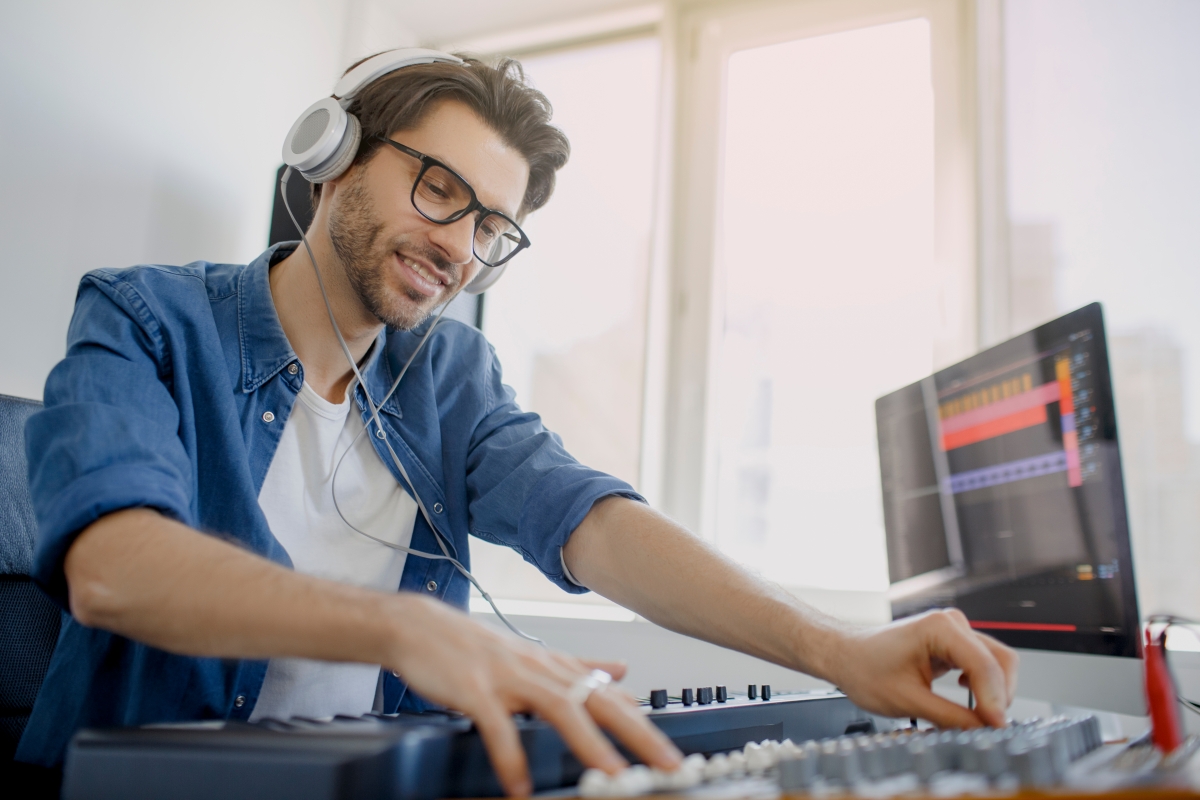 man wearing headphones operating recording equipment