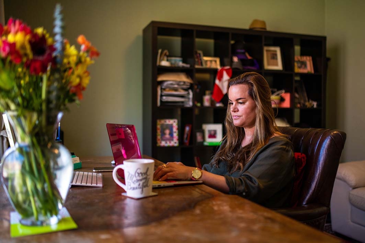 woman on laptop with mug in home office