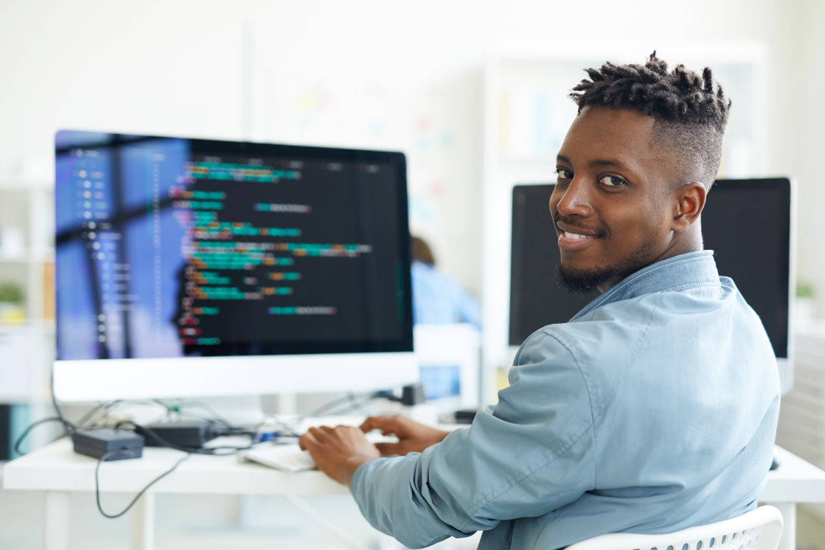 person typing code on a desktop computer