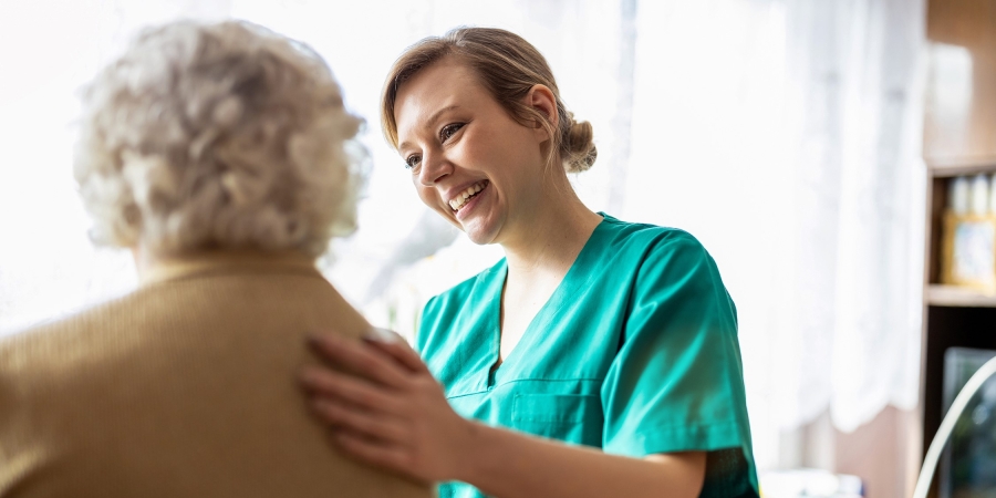 Female nurse comforting elderly patient
