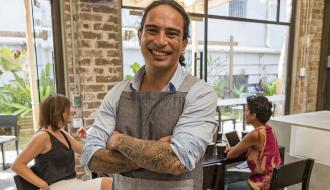 smiling male store owner with arms crossed 